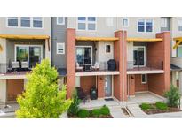 Townhome featuring a private balcony with outdoor seating and manicured landscaping at 7808 W 43Rd Pl, Wheat Ridge, CO 80033