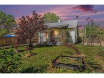 Charming home featuring a landscaped front yard with decorative trees and a classic red front door at 4635 Teller St, Wheat Ridge, CO 80033
