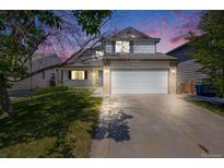Charming two-story home featuring a well-manicured lawn, attached two car garage, and inviting front porch at 11727 Oswego St, Commerce City, CO 80640