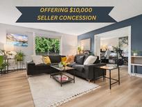 Bright living room featuring a modern gray sofa, area rug, and sliding glass doors to the outside at 7040 E Girard Ave # 207, Denver, CO 80224