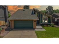Charming two-story home featuring an attached two-car garage and landscaped front yard at 3883 S Fraser St, Aurora, CO 80014