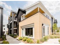 Modern condo exterior with brick accents, balconies, and landscaped grounds at 8260 E 36Th Ave # 29, Denver, CO 80238