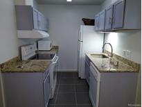 A functional kitchen with modern appliances, granite countertops and grey cabinets at 10792 E Exposition Ave Ave # 254, Aurora, CO 80012
