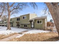 Charming two-story townhome with a walkway and snowy front yard, surrounded by mature trees at 5721 W 92Nd Ave # 52, Westminster, CO 80031