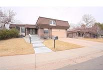 Charming brick home with a unique roof, tidy front yard, and attached two car garage at 3957 S Peach Way, Denver, CO 80237