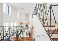 Bright living room with fireplace, hardwood floors, and wrought iron staircase at 3957 S Peach Way, Denver, CO 80237