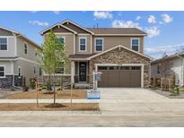 Charming two-story home with stone accents, a two-car garage, and a well-manicured lawn at 24748 E 40Th Ave, Aurora, CO 80019