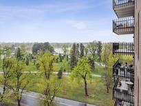 A scenic view from the balcony showcases a park and a lake at 480 S Marion Pkwy # 901, Denver, CO 80209