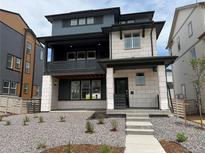 Modern two-story home boasting mixed siding, a covered porch, and professional landscaping at 7260 Waterleaf Trl, Littleton, CO 80125