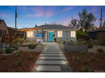 Charming gray brick home featuring a walkway to a bright blue front door and artistic modern landscaping at 822 Poplar St, Denver, CO 80220