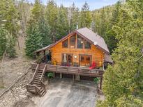 Stunning log home with expansive deck, nestled amongst the trees, and featuring an attached garage for convenience at 1673 Sinton Rd, Evergreen, CO 80439