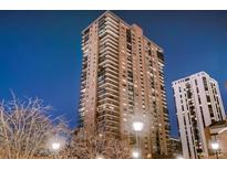 Stunning high-rise building with many floors and balconies against a blue sky at twilight at 1551 Larimer St # 1402, Denver, CO 80202