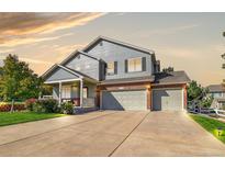 Beautiful two-story home with a brick-accented three-car garage and cozy covered front porch at 3779 Aspen Hollow Ct, Castle Rock, CO 80104