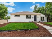 Charming one-story home featuring a well-maintained front lawn, mulch landscaping, and a brick facade at 1330 Quebec St, Denver, CO 80220