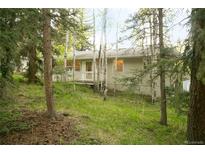 Charming single story home in a wooded setting featuring a cozy front porch at 29055 S Sunset Trl, Conifer, CO 80433