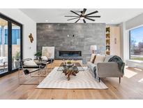 Inviting living room featuring a modern fireplace, stylish decor, and wood floors at 2630 N Perry St, Denver, CO 80212