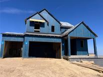 Two-story home under construction featuring an attached two car garage and porch on a sunny day at 39735 Gibson St, Elizabeth, CO 80107