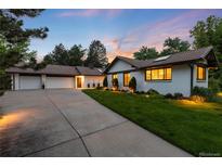 Beautiful home exterior with a well-manicured lawn and a long driveway leading to a two-car garage at 1 Club Ln, Littleton, CO 80123