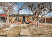 Brick ranch home with mature trees and a landscaped yard at 7040 Alan Dr, Denver, CO 80221