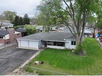 Charming single-story home with a two-car garage, front porch, and spacious, tree-lined backyard at 14185 W 50Th Ave, Golden, CO 80403