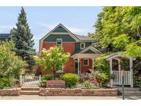 Charming two-story townhome with brick and green siding, beautiful landscaping, and inviting front entrance at 1824 Pearl St # B, Boulder, CO 80302