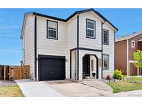 Charming two-story home with black trim, garage, manicured lawn, and welcoming front entrance at 10042 Hudson St, Thornton, CO 80229