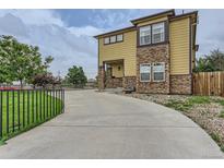 Stylish two-story home with a stone and siding exterior, concrete driveway, and manicured lawn at 4190 W Alameda Ave, Denver, CO 80219