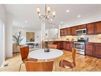 Bright kitchen featuring wood cabinets, granite counters, stainless appliances, and hardwood floors at 4190 W Alameda Ave, Denver, CO 80219