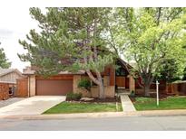 Charming brick home featuring mature trees, a two-car garage, and a well-maintained front yard at 10572 E Orchard Pl, Englewood, CO 80111