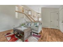 Inviting living room with hardwood floors, a cozy couch, and a staircase leading to the upper level at 19140 E Milan Cir, Aurora, CO 80013