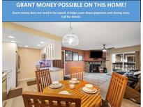 Cozy living room featuring a fireplace, dining area, and access to the outdoors at 3482 S Eagle St # 102, Aurora, CO 80014