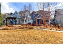 Charming blue home with a well-kept front yard and mature trees, showcasing curb appeal at 5068 Uinta St, Denver, CO 80238
