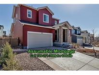 Charming two-story home featuring a two-car garage, stone pillar entry, and landscaped front yard at 4840 Point Mesa St, Castle Rock, CO 80108