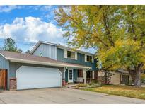 Two-story home with attached garage, mature tree, and landscaped yard at 3357 S Oneida Way, Denver, CO 80224