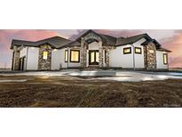 Stunning two-story home with a stone and white exterior at 30410 E 161St Ave, Brighton, CO 80603