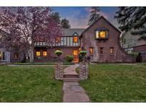 Charming two-story brick home with lush landscaping and a stone walkway leading to the front door at 239 Ash St, Denver, CO 80220