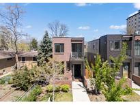 Modern two-story brick home featuring a balcony and lush landscaping at 1833 E Jewell Ave, Denver, CO 80210