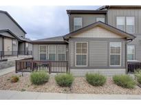 Charming townhome exterior with a private porch and landscaped with decorative rock and shrubbery at 11568 Dewey St, Parker, CO 80138