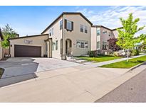 Charming two-story home featuring a basketball hoop over the garage and well-manicured front yard at 15547 W Vassar Ave, Lakewood, CO 80228