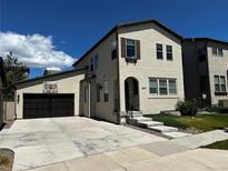 Charming two-story home featuring an attached garage, landscaped front yard and concrete driveway on a sunny day at 15547 W Vassar Ave, Lakewood, CO 80228