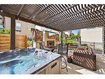 Inviting covered patio with hot tub, fireplace, comfortable seating and a large outdoor television for entertaining at 15547 W Vassar Ave, Lakewood, CO 80228