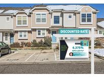 Charming townhome exterior with light blue doors and professional real estate marketing sign at 5888 Biscay St # D, Denver, CO 80249