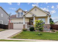 Charming two-story home featuring a welcoming porch, well-manicured lawn, and an attached two-car garage at 4293 Clover Ln, Brighton, CO 80601