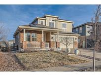 Two-story brick home with solar panels and landscaped yard at 6938 S Riverwood Way, Aurora, CO 80016