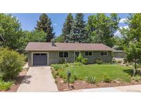 Charming single-story home with a lush green lawn, mature trees, and an attached garage at 3545 Cloverleaf Dr, Boulder, CO 80304