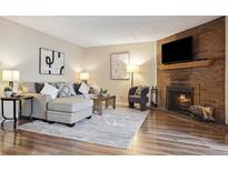 Inviting living room featuring a brick fireplace and neutral toned decor at 3343 S Monaco Pkwy # A, Denver, CO 80222
