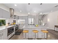 Modern kitchen with stainless steel appliances, island with seating, and gray cabinets at 1333 Elati St # 1, Denver, CO 80204