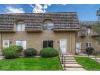 Charming townhome featuring unique wood roofing, neutral stucco, manicured lawn, and inviting front entrances at 7412 E Princeton Ave, Denver, CO 80237