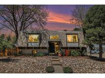 Inviting home featuring a unique roofline, stone landscaping, and a serene, tree-lined setting at 9349 E Chenango Ave, Greenwood Village, CO 80111