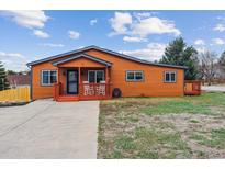 Charming single-story home with orange siding, cozy front porch, and well-maintained lawn at 176 W Elm St, Elizabeth, CO 80107